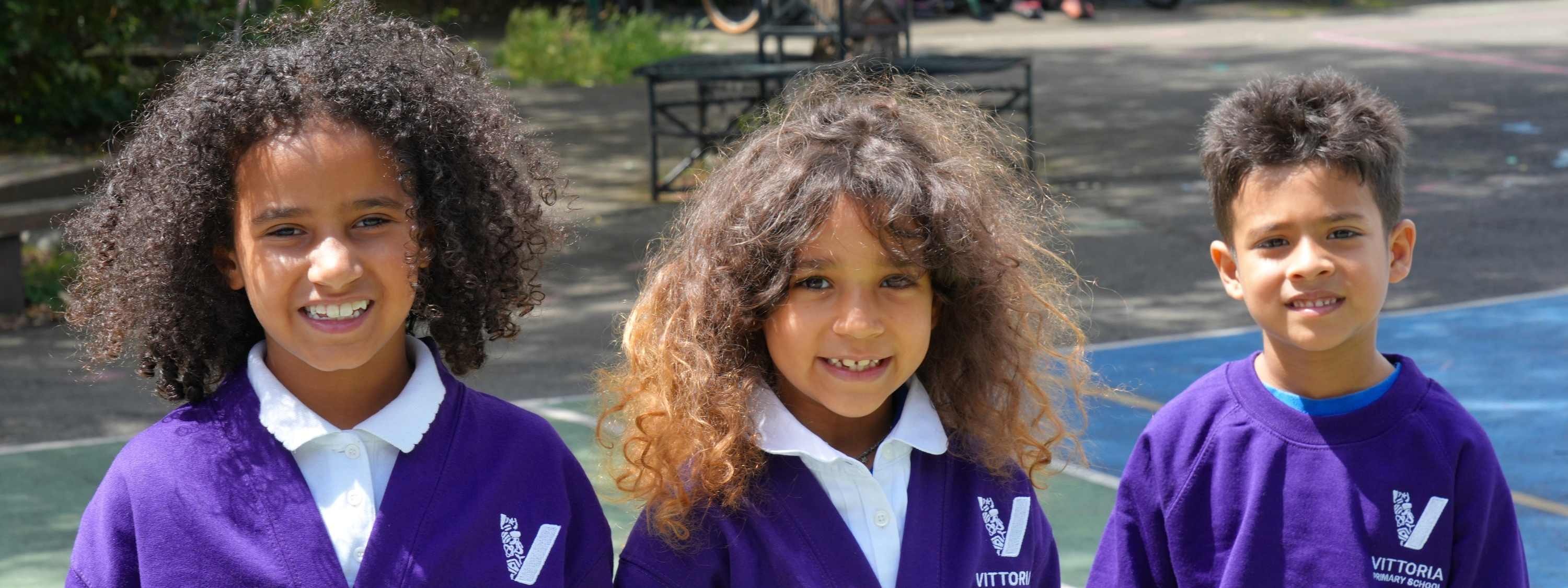 Vittoria Primary School - Three children smiling in playground