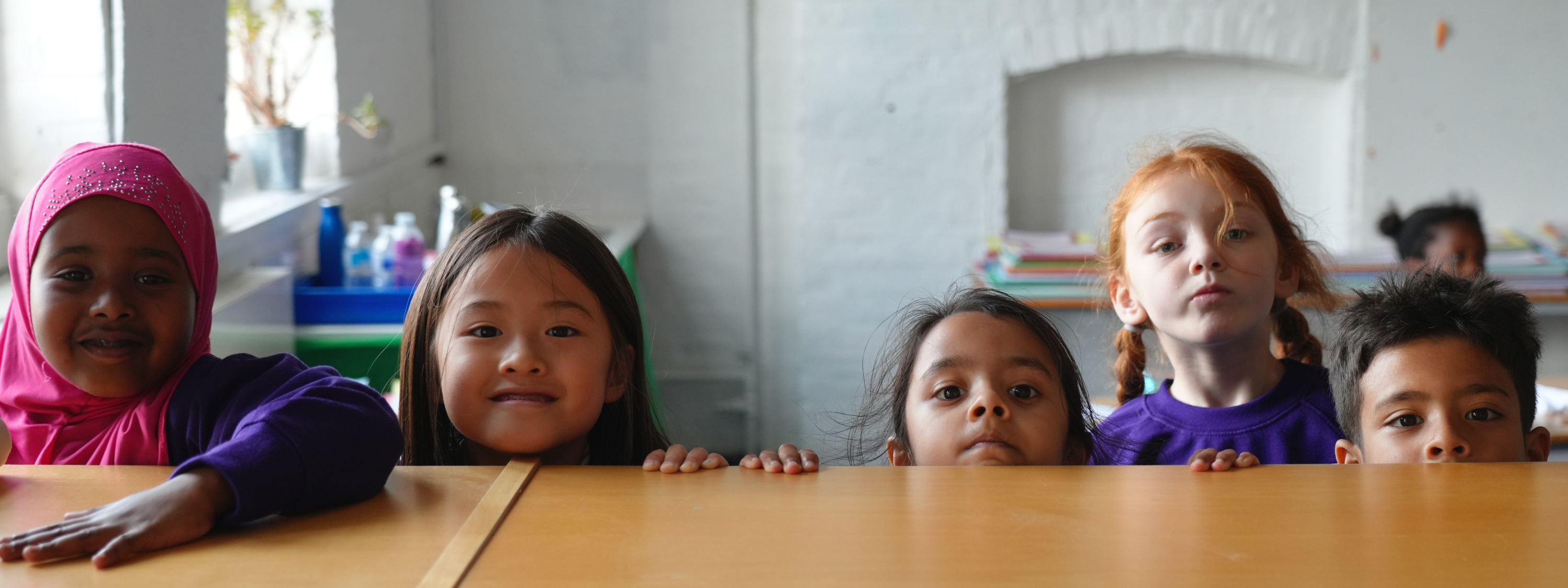 Vittoria primary school - children peering over table in classroom